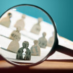 Business recruitment or hiring photo concept. Looking for talent. Icons of candidates are standing on open newspaper under magnifier.