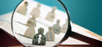 Business recruitment or hiring photo concept. Looking for talent. Icons of candidates are standing on open newspaper under magnifier.