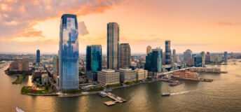 Aerial panorama of Jersey City skyline at sunset.